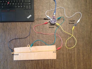 An Arduino LilyPad takes input from a soft potentiometer which determines the tone played on the buzzer.